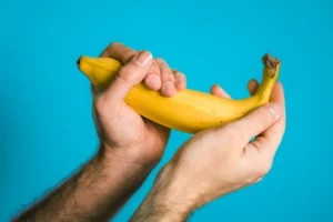 Ein Mann hat mit seinen Händen eine Banane in der Hand