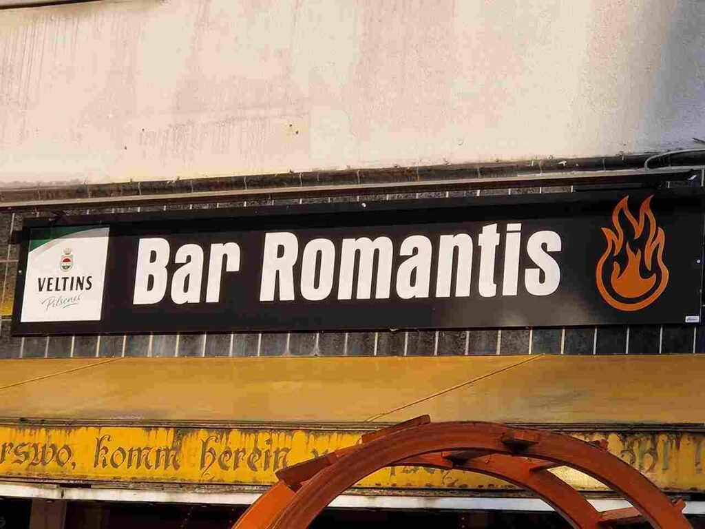 Das Logo der Bar Romantis Hannover. Schriftzug der Bar in weißer Schrift auf schwarzem Hintergrund