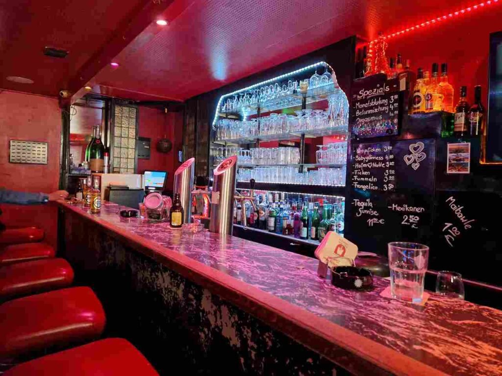 Blick auf die Theke der Bar Kunterbunt Hamburg. Diese ist hell erleuchtet.
