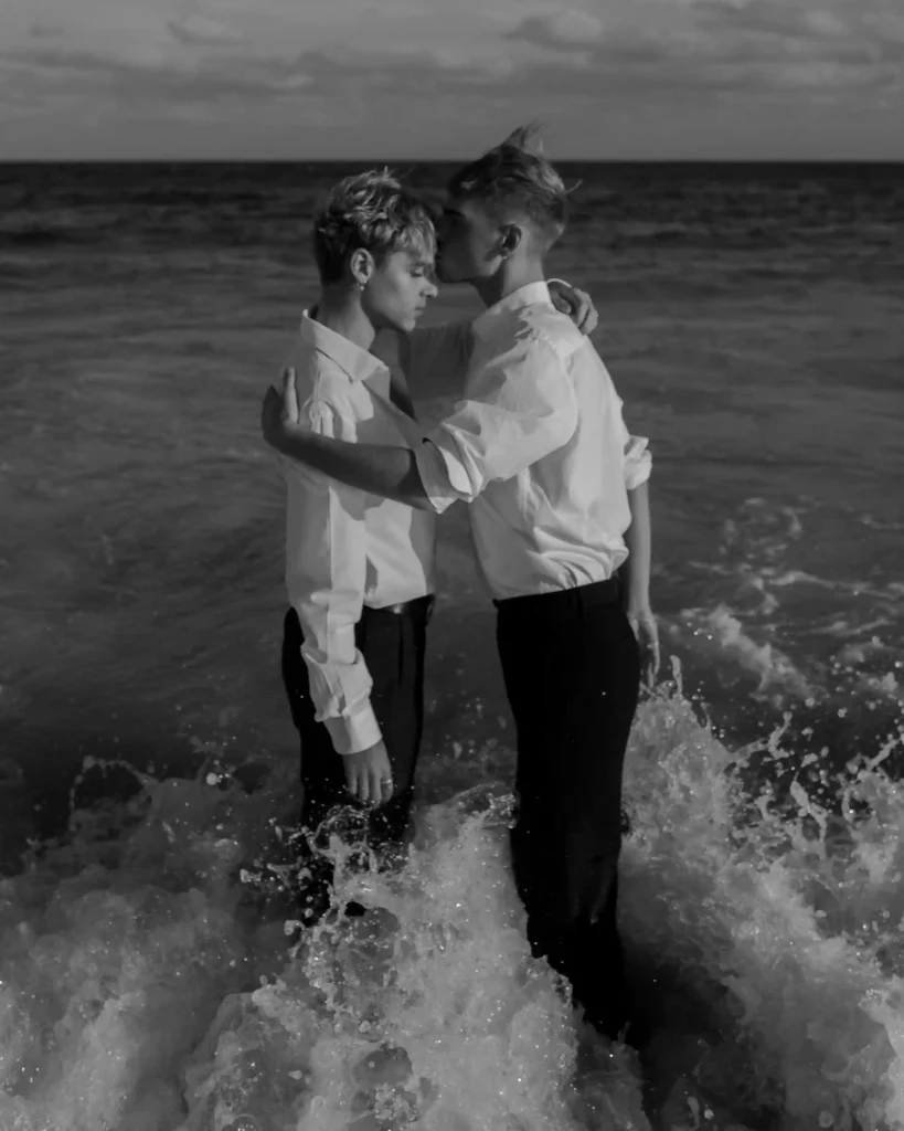 Zwei Männer umarmen sich am Strand im Meer
