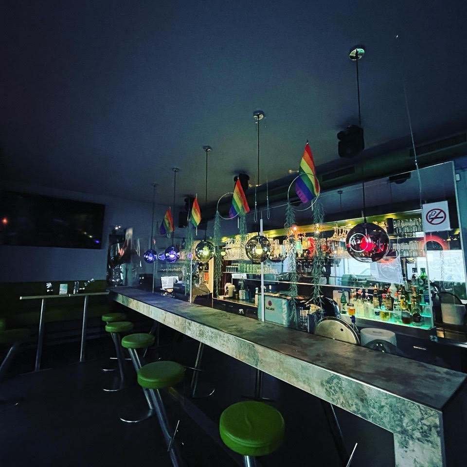 Theke der Village Bar in Wien mit Regenbogenfahnen