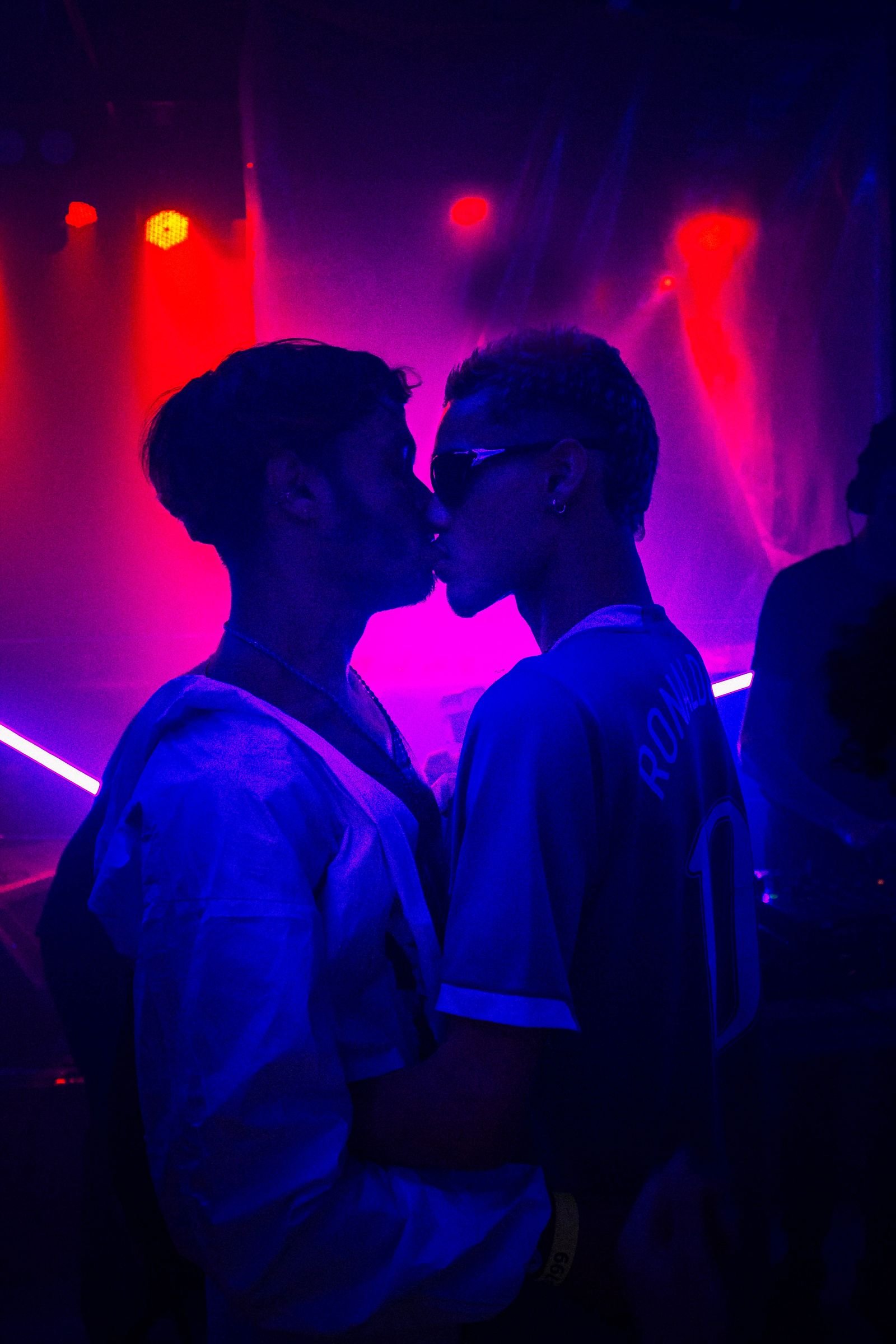 Zwei Männer im Neonlicht eines Clubs